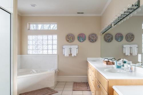Baño blanco con bañera y lavamanos en Family Getaway-Hot Tub, Ice Castles & Tubing HS home, en Midway
