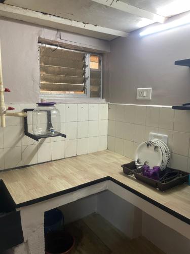 um quarto com um lavatório numa cozinha com uma janela em Vinoth home stay service apartment em Chennai
