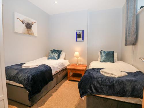 a bedroom with two beds and a picture of a sheep at Granary in Ulverston