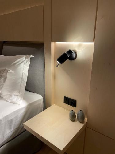 Dormitorio con mesita de noche con lámpara y mesa en Mr(s)STiL Design Apartments en Berlín