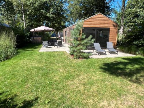 a yard with a group of chairs and an umbrella at Holiday Home Maridu Wellness in Arnhem