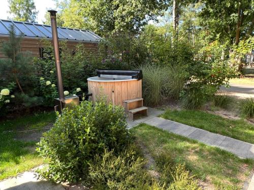 アーネムにあるHoliday Home Maridu Wellnessのホットタブ、庭園内のベンチを提供しています。