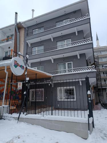 a building in the snow with a sign in front of it at Deeps Hostel Ankara 2 in Ankara
