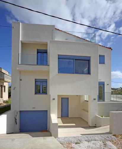 a white house with a blue garage at Ciel Villa in Kalyves