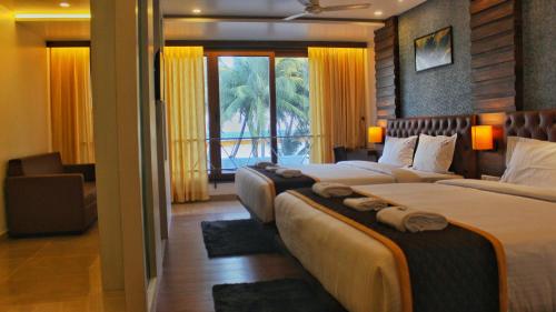 a hotel room with two beds and a window at HOTEL IDHAYA in Port Blair