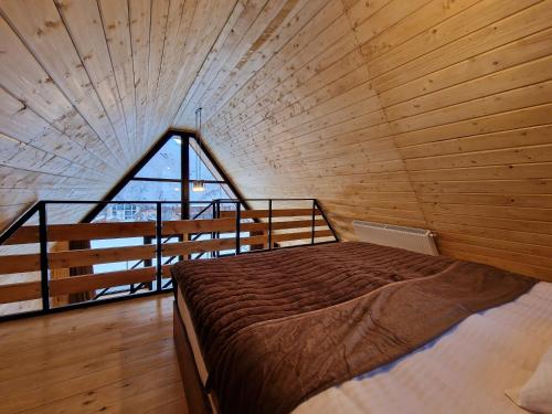 Kera cottages kazbegi في كازباجي: سرير كبير في غرفة مع نافذة كبيرة