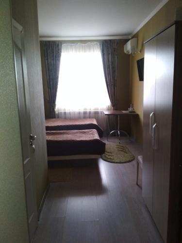 a small bedroom with a bed and a window at Dalos Plus in Sarny