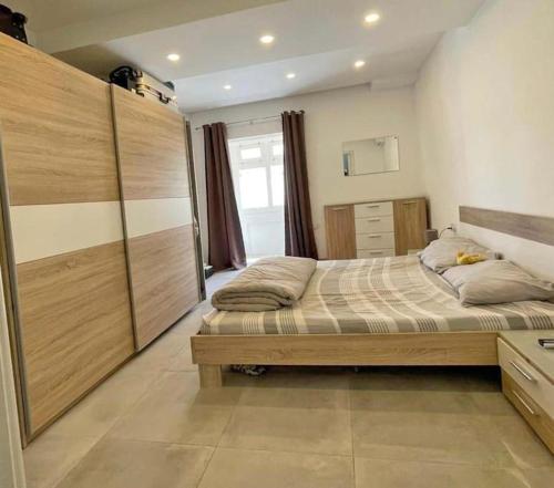 Un dormitorio con una cama grande con armarios de madera. en Spacious and beautiful flat in Gzira, en Il-Gżira