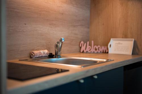 a kitchen counter with a sink and a sign at Mobile homes Tina Pakoštane in Pakoštane