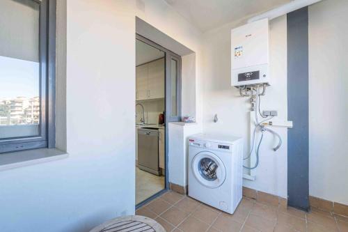 a laundry room with a washing machine and a window at Goldhome - Cristallmar in Empuriabrava