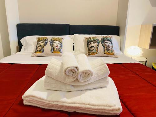 a bed with white towels and portraits of jesus at I Cinque Mori DEVA in Siracusa