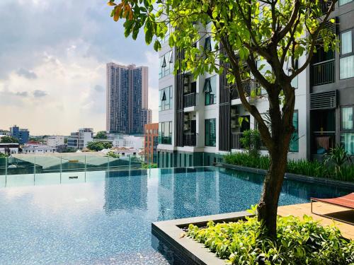 a swimming pool with a tree in the middle of a building at Two bedrooms and two bathrooms Thonglor in Bangkok