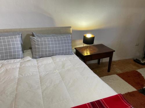 a bedroom with a bed with a lamp on a table at PIAZZETTA DEL FORNO appartamento in Assergi