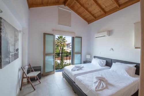 ein Schlafzimmer mit einem großen Bett und einem Stuhl in der Unterkunft Kymma Villas by the Sea in Ayia Napa