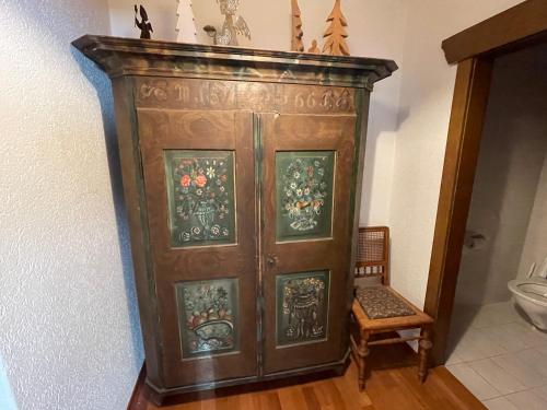 a large wooden cabinet in a room with a chair at Haus Erna in Gundersheim