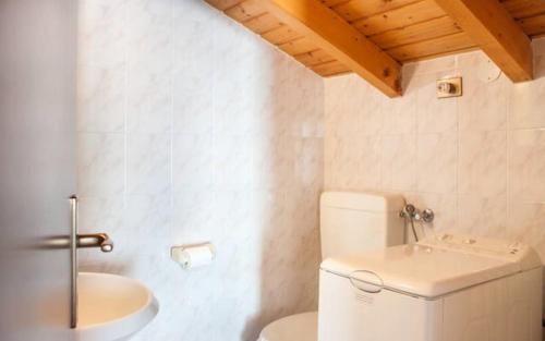 a white bathroom with a toilet and a sink at Appartamento MANUELA in Consiglio di Rumo