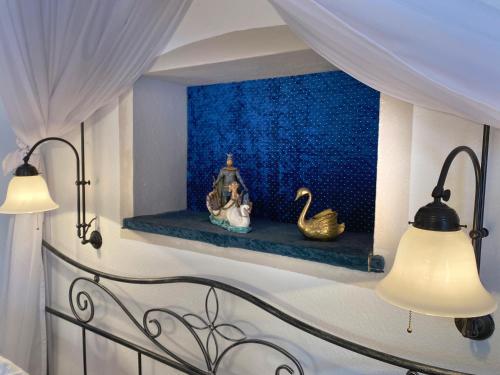 a bedroom with a bed with two lamps on a shelf at Haus bei der Linden Ferienwohnungen in Schwangau
