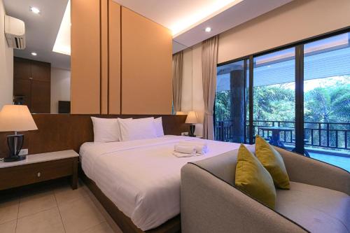 Ban Bo WiにあるSuanphung Bonsai Villageのベッドとソファ付きのホテルルーム