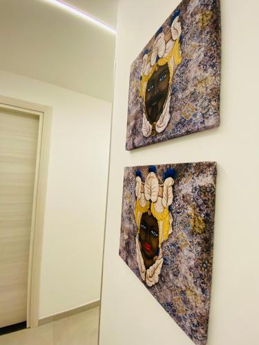 two paintings of a woman on a wall at I Cinque Mori DEVA in Siracusa