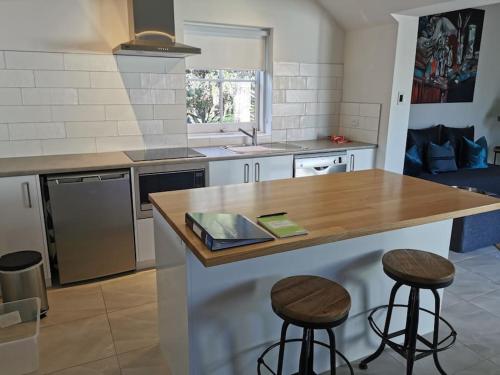 a kitchen with a counter and two bar stools at The Shoemaker's Cottage in Richmond