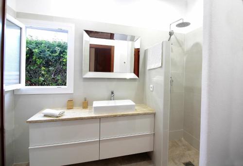 W białej łazience znajduje się umywalka i lustro. w obiekcie Casas Palma Zahora Piscina Privada w mieście Zahora