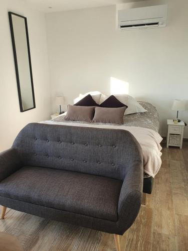 a bedroom with a bed and a couch in it at Instant secret in Pourrières