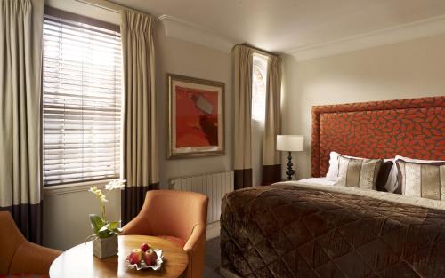 um quarto com uma cama, uma mesa e uma cadeira em The Arden Hotel Stratford - Eden Hotel Collection em Stratford-upon-Avon