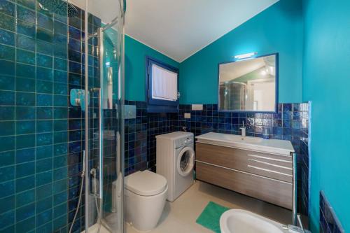 ein blaues Badezimmer mit einem WC-Waschbecken und einer Dusche in der Unterkunft Cala Azzurra a Fetovaia - Goelba in Fetovaia