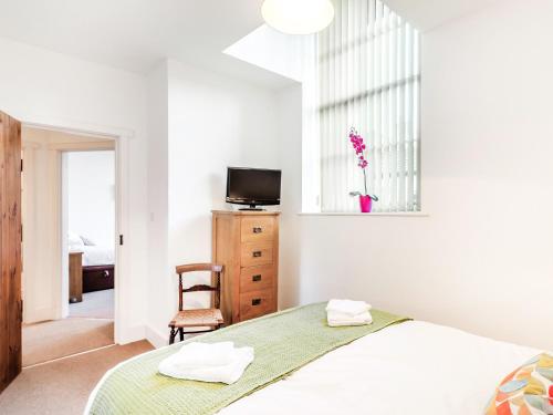 a bedroom with a bed and a tv and a chair at Riding Cottage - Uk37449 in Pateley Bridge