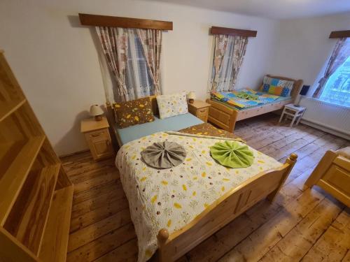 ein kleines Schlafzimmer mit einem Bett und einem Kinderbett in der Unterkunft Rodinná chalupa jen pro sebe in Harrachov