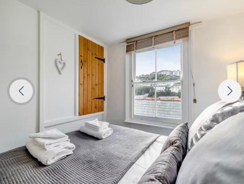 a white bedroom with a bed with towels on it at Fulmar Cottage in Mevagissey