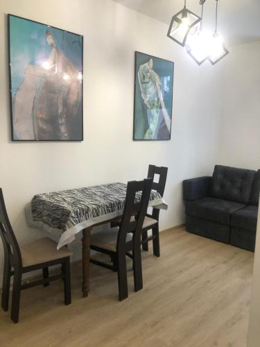 a living room with a table and chairs and a couch at Apartament Rodzinny L7 in Kalisz