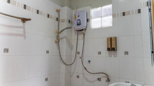 a shower in a white bathroom with a sink and a shower at Mao Pha Sok Guesthouse in Luang Prabang