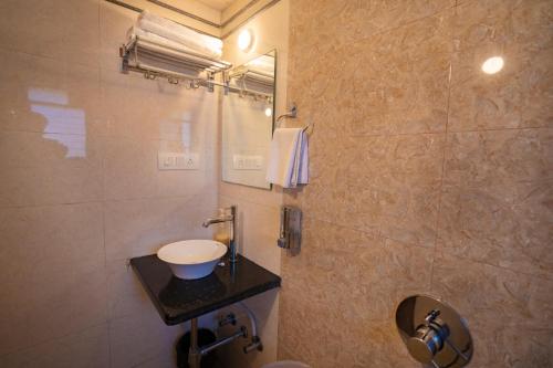 a bathroom with a sink and a shower at Hotel Jagadguru Lonavala in Lonavala