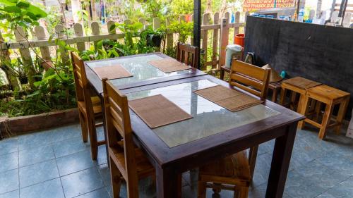 a wooden table and chairs on a patio at Mao Pha Sok Guesthouse in Luang Prabang