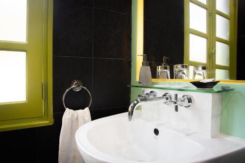 ein Badezimmer mit einem weißen Waschbecken und einem Spiegel in der Unterkunft Villa Maly Boutique Hotel in Luang Prabang
