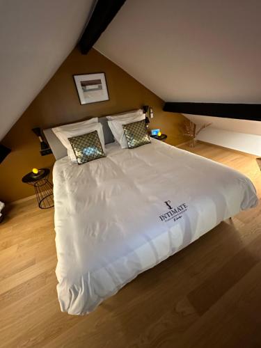 1 dormitorio con 1 cama grande con sábanas y almohadas blancas en Intimate - Private Wellness, en Héron
