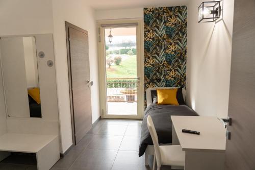 a bedroom with a bed and a desk and a window at Piscina San Lorenzo in Santhià