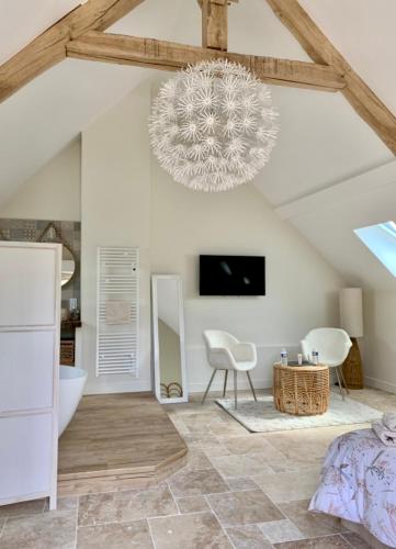 a bedroom with a bed and a chandelier at Chambres d'hôtes L'Escale Charmante in Choussy