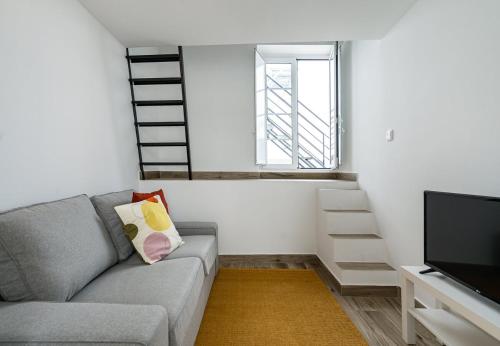 a living room with a couch and a television at Tia Anica House II - apartment with terrace in central Fuseta beach village in Fuzeta