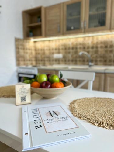 a book sitting on a table with a bowl of fruit at LA Casa Di Lusso N3 - Adults Only in Kolimbia