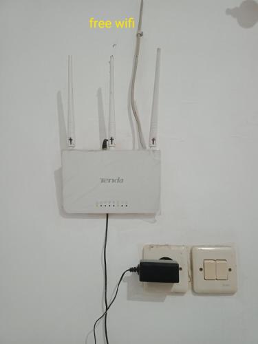 a wall with a whiteounter with a plug and a charger at Mutiara Dieng in Wonosobo