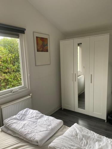 a bedroom with a bed and a large window at Chalet Bergen NH, Schoorl, Schoorldam in Warmenhuizen