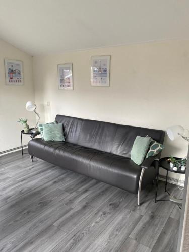 a black leather couch in a living room at Chalet Bergen NH, Schoorl, Schoorldam in Warmenhuizen
