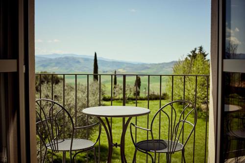 a table and chairs on a balcony with a view at Hotel Corsignano in Pienza