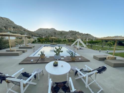 a patio with a table and chairs and a pool at LA Casa Di Lusso N3 - Adults Only in Kolimbia