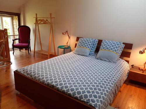 a bedroom with a bed with a blue comforter at " Chez Alex " 