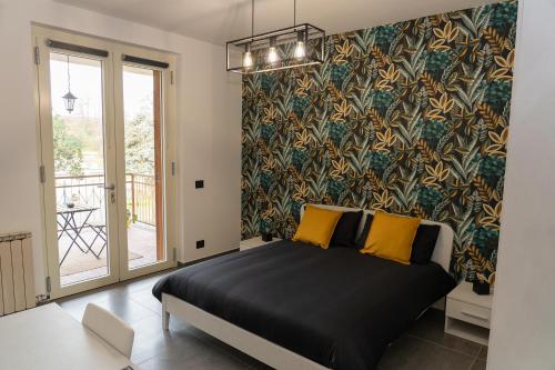 桑特伊阿的住宿－Piscina San Lorenzo，一间卧室配有一张黑色床和彩色壁纸
