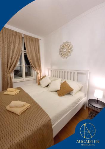 - une chambre blanche avec 2 lits et une fenêtre dans l'établissement Augarten Apartments, à Vienne