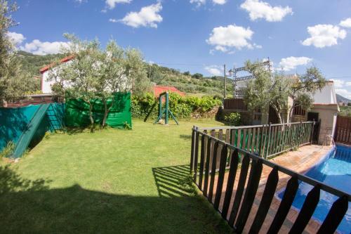 a backyard with a swimming pool and a fence at La Charca de la Dehesa in Casas del Monte